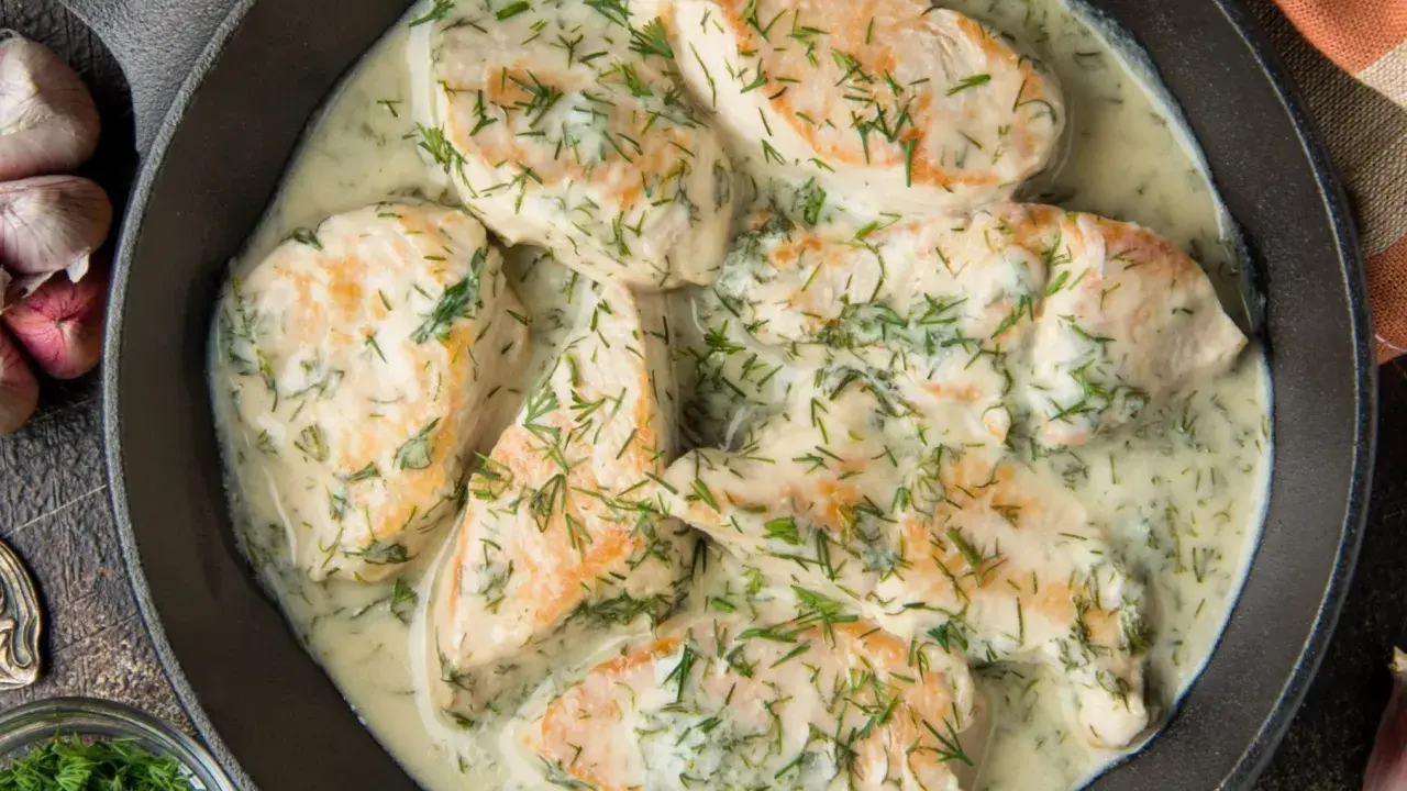 Pyszny kurczak w sosie śmietanowym z koperkiem, podany w żeliwnej patelni. Aromatyczny i kremowy.