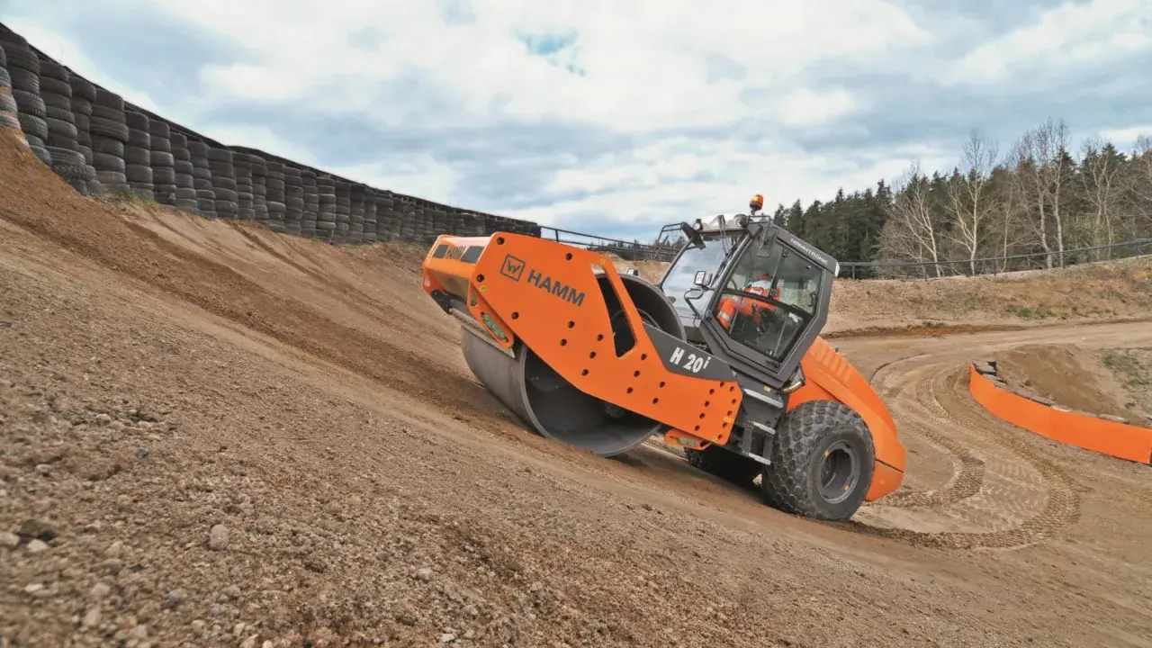 Rodillo Hamm H 20i trabajando en una pendiente, realizando la compactación del suelo.