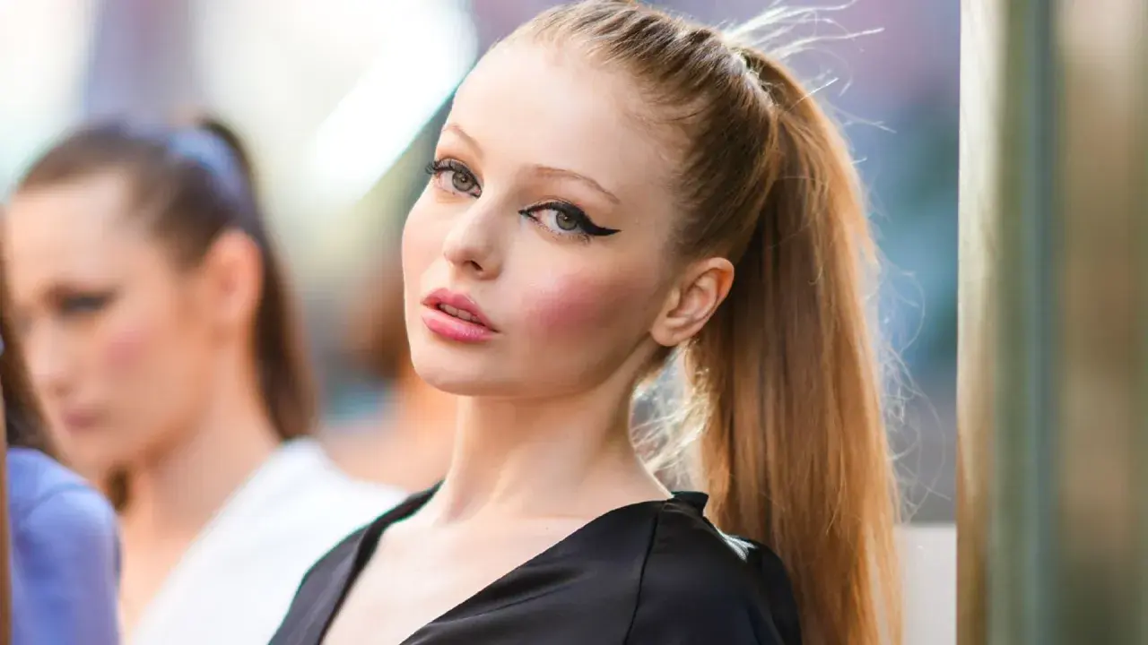 Modelo con delineado cat eye dramático y labios rosados, su cabello recogido en una coleta alta.