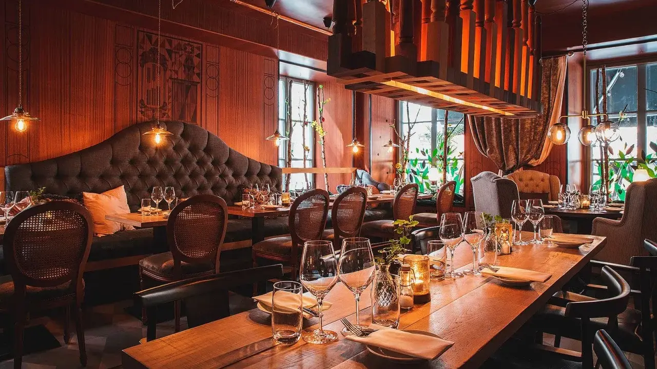 En klassisk restaurang i Gamla Stan med sammetsklädd soffa, rottingstolar och vackert dukade bord.