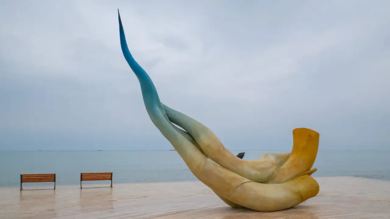 Rzeźba na promenadzie w Durrës, idealne miejsce, by zobaczyć zachód słońca. Dwie ławki czekają na spacerowiczów.