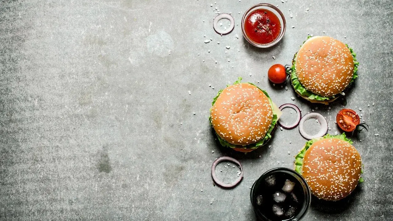 Tre saftiga hamburgare, en skål med ketchup, tomater, rödlök och en läsk med is. Perfekt för en mysig kväll på vår western grillhouse.
