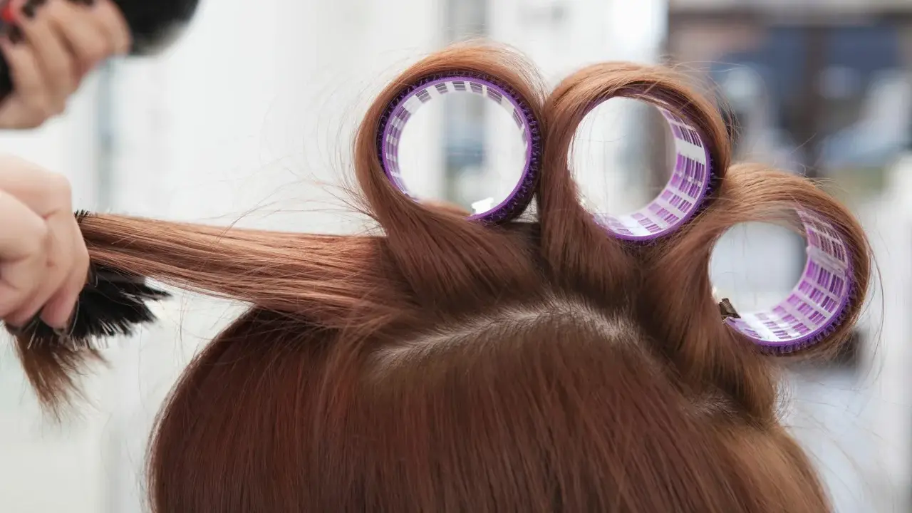Profesjonalny styling włosów: lokówka i szczotka tworzą objętość.