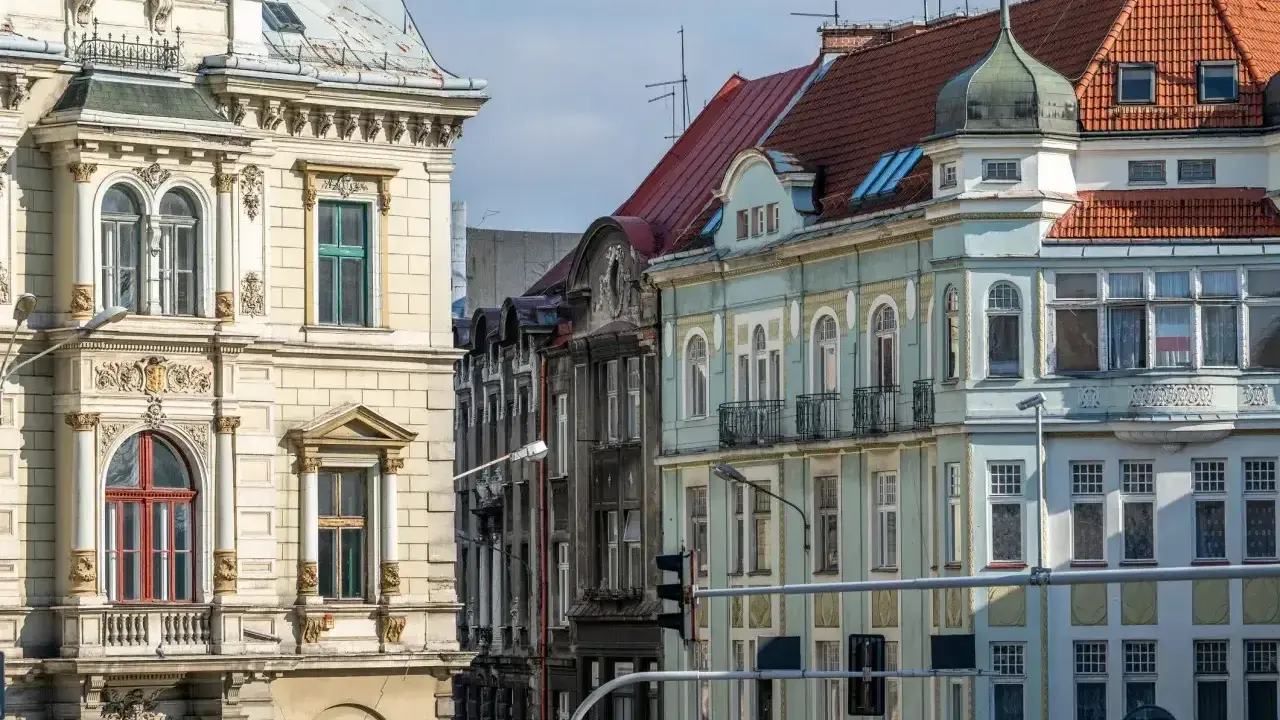 Kamienice na rynku w Bielsku-Białej, z bogatymi zdobieniami i różnorodnymi dachami, tworzą malowniczy widok.