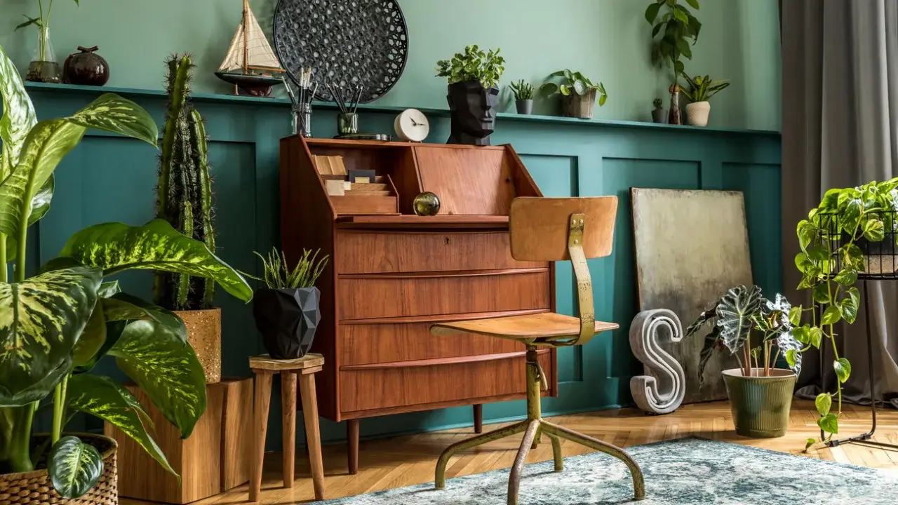 Wnętrze w stylu retro: drewniane biurko, krzesło, rośliny i dekoracje tworzą przytulną atmosferę.
