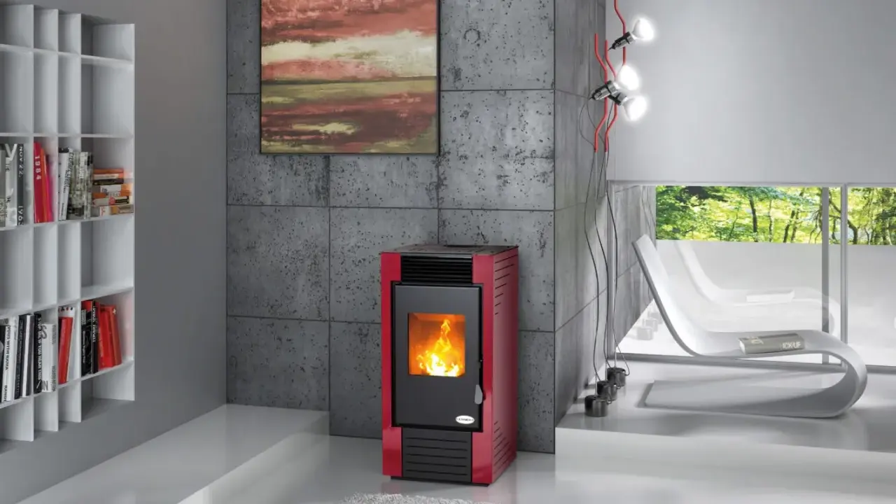 Estufa de leña o pellets roja con fuego encendido, junto a una estantería blanca y un sillón curvo.