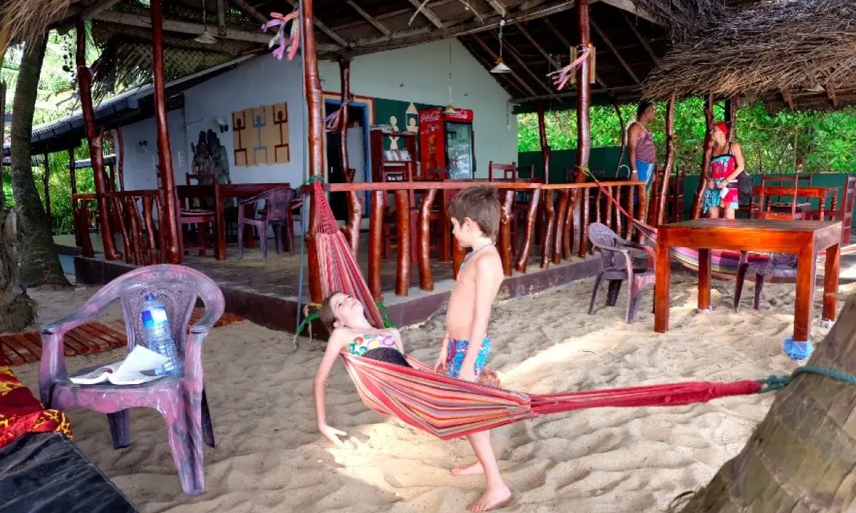 Niños disfrutan de una hamaca en una playa de Sri Lanka. Un paraíso tropical para familias.