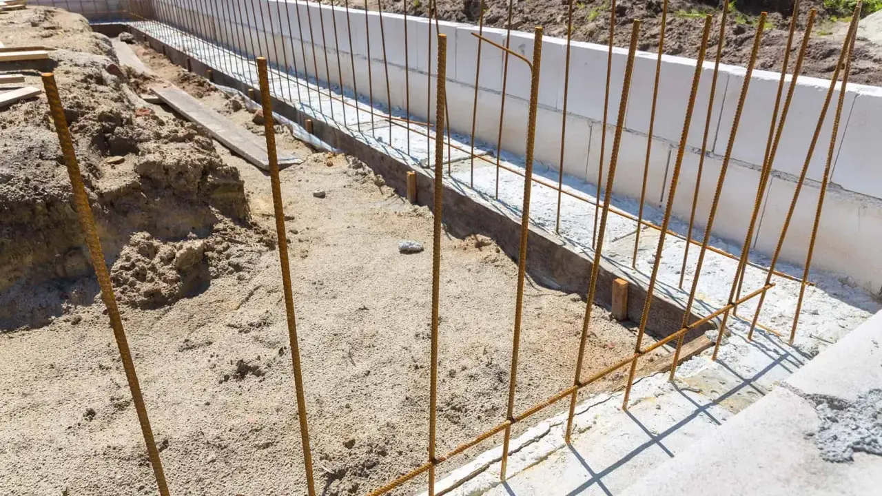 Zbrojenie fundamentu w trakcie budowy, stalowe pręty tworzą ruszt dla przyszłego betonu.
