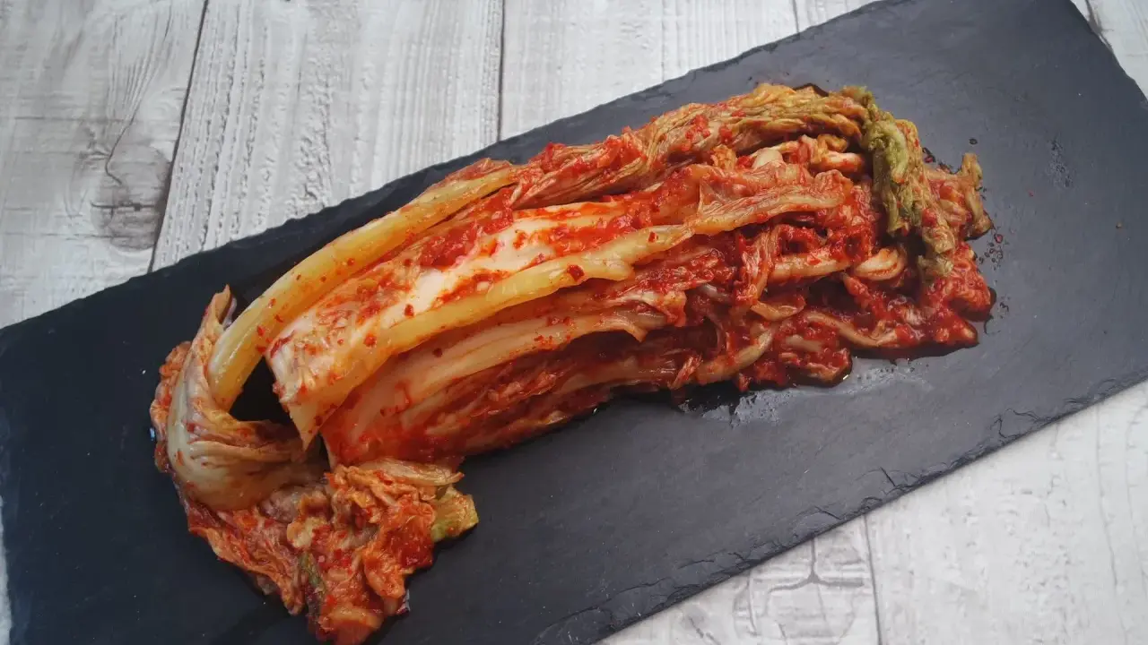Frisch zubereitetes Kimchi, das beste Kimchi Rezept, liegt auf einem schwarzen Stein.