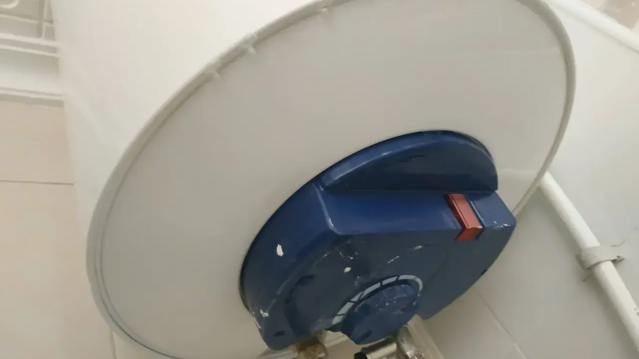 El termo gotea por abajo, mostrando una fuga de agua en la parte inferior del calentador.