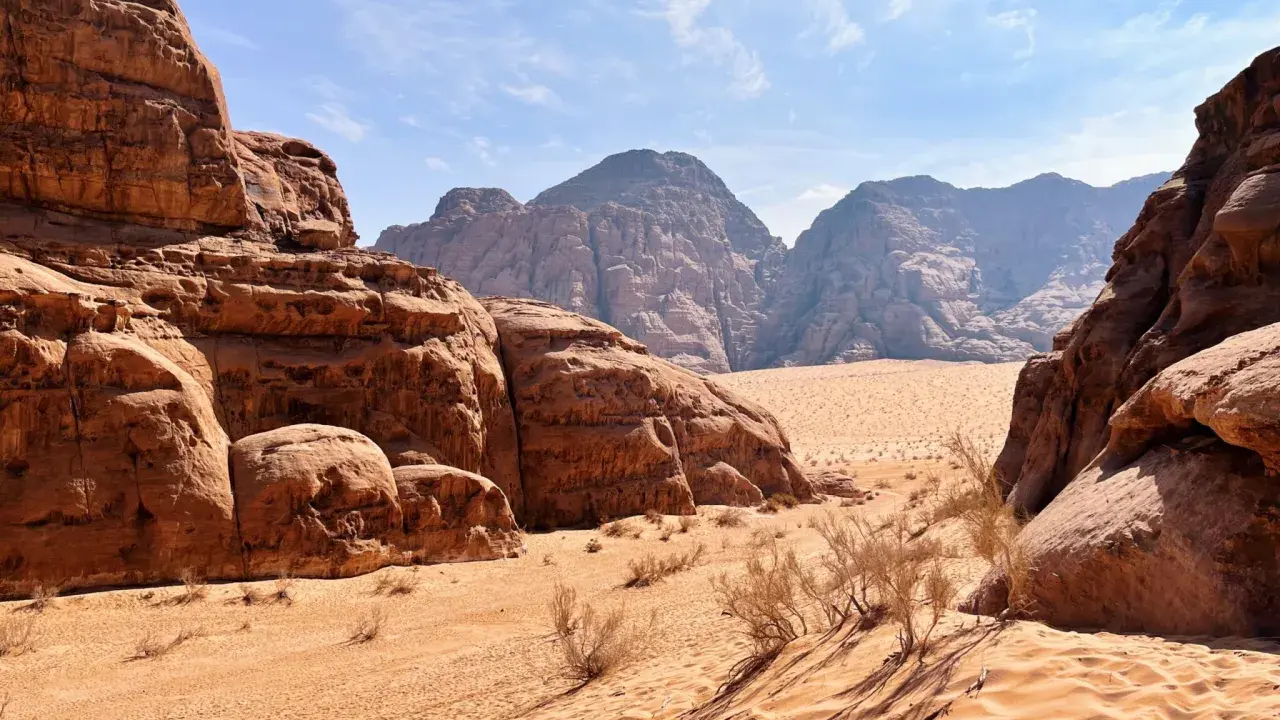 Pustynia w Jordanii, Wadi Rum. Piaskowe wydmy i skalne formacje pod błękitnym niebem.