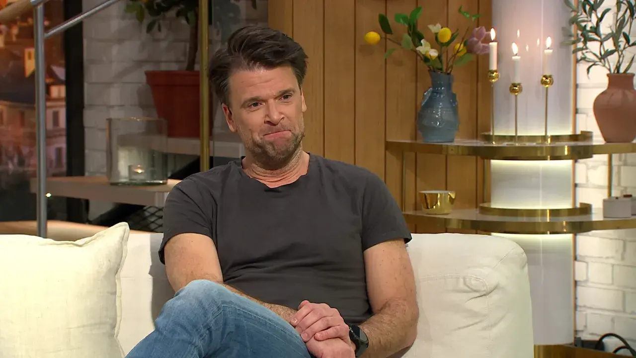 Peter Magnusson sitter i en soffa, kanske redo att prata om sina filmer och tv-program.