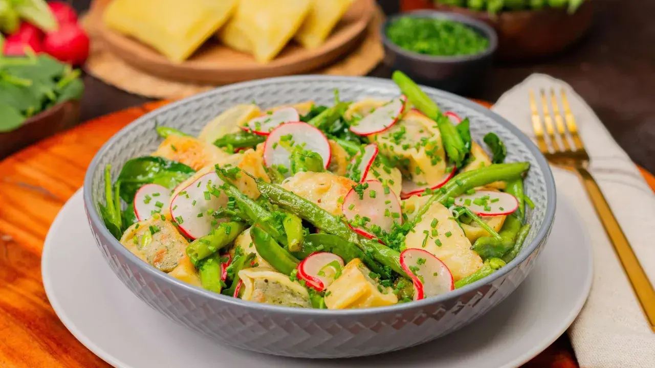 Schüssel mit Maultaschen Salat, grünen Bohnen, Radieschen und Schnittlauch. Ein köstlicher Maultaschen Salat für den Sommer.
