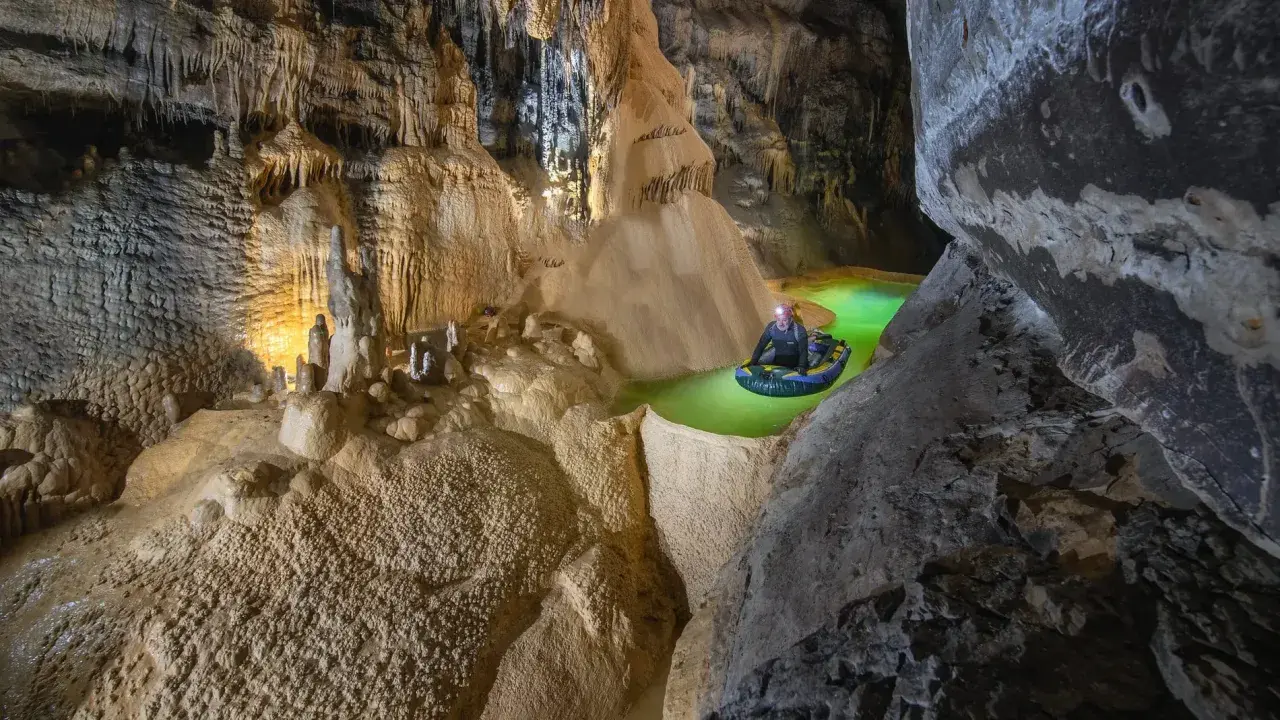 Explorador en balsa por el ojo guareña, un río subterráneo de aguas verdes y formaciones rocosas impresionantes.