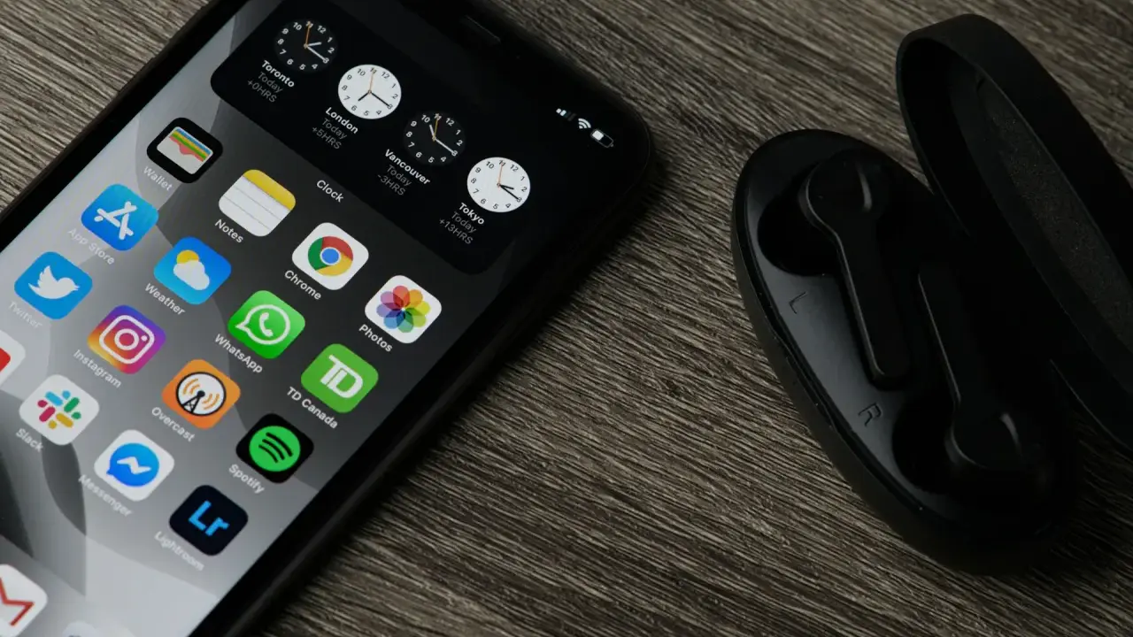 Chcesz wiedzieć, jak zaktualizować iPhone? Na ekranie widać ikony aplikacji, zegary i słuchawki.