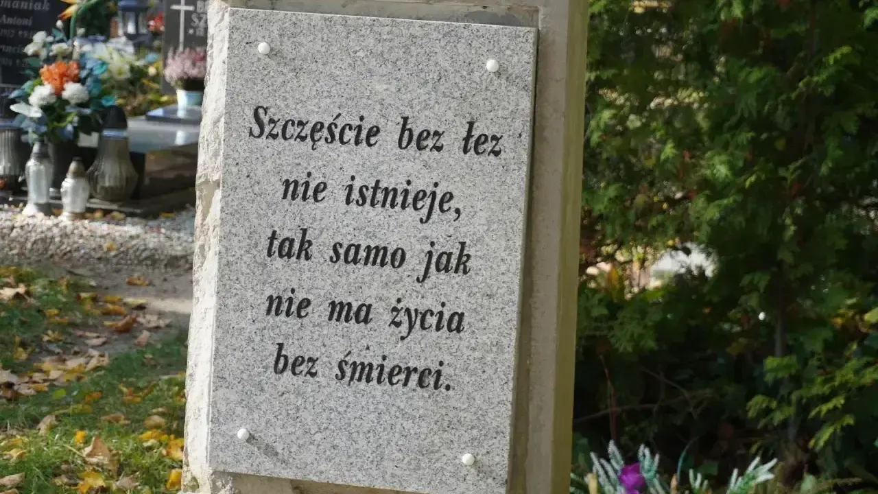 Kamienna płyta z cytatem o życiu i śmierci na cmentarzu, gdzie odbywa się pochówek urny.