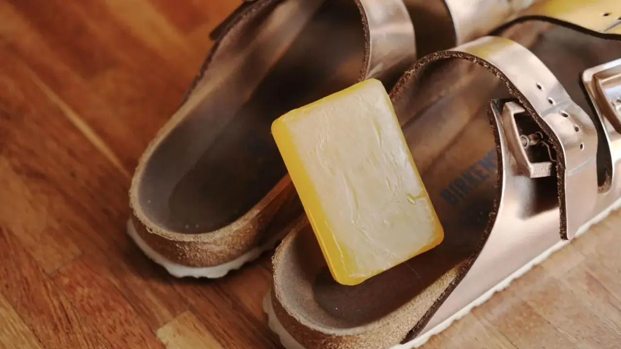 Kostka mydła obok sandałów Birkenstock, gotowa do czyszczenia.