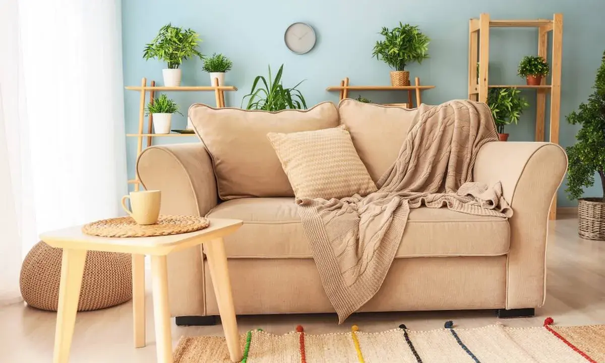 Un plaid douillet drapé sur un canapé beige, invitant à la détente. Idéal pour savoir comment mettre un plaid sur un canapé avec style.