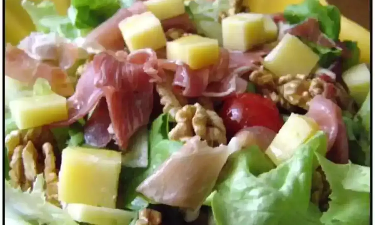 Salade fraîche avec jambon cru, dés de fromage, noix et tomates cerises. Une belle entrée auvergnate pour un repas léger.
