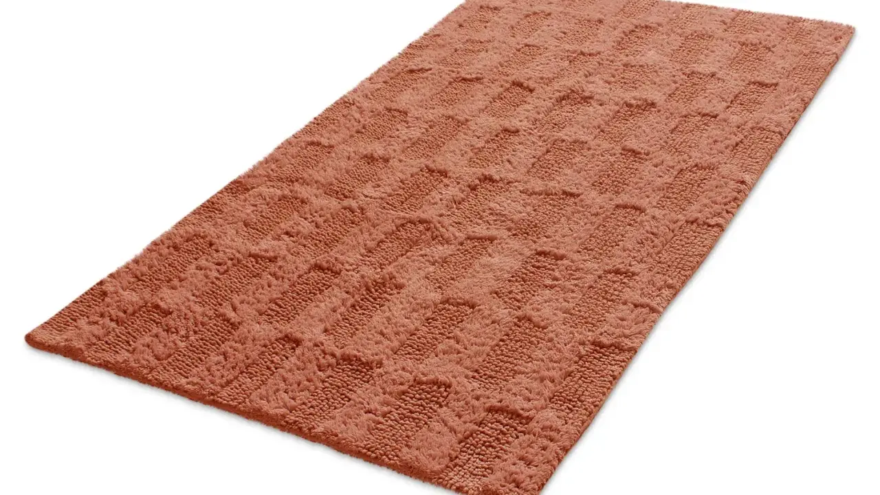 En mjuk, orange badrumsmatta med ett rutmönster. Den ger en varm och inbjudande känsla.
