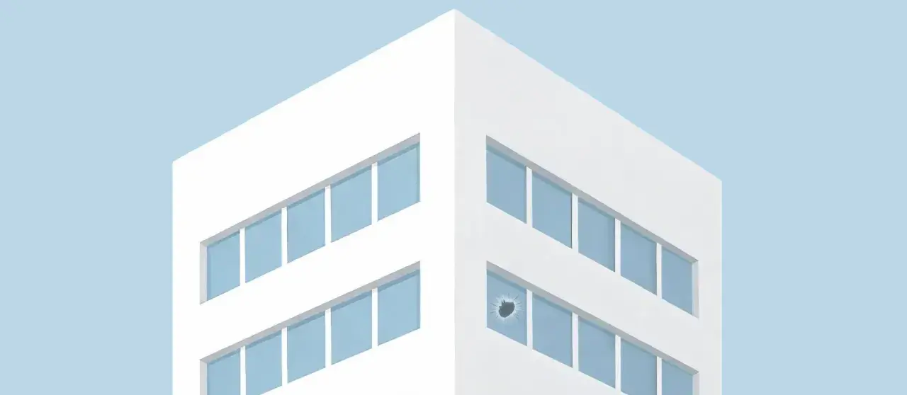 Ein modernes Gebäude mit blauen Fenstern, eines davon mit **broken windows** – ein deutliches Zeichen für eine unerwartete Störung.