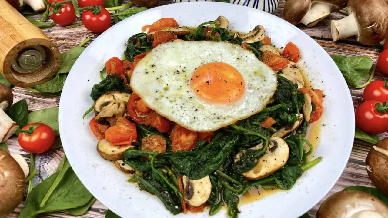 Herzhaftes Gericht mit Baby Spinat, Tomaten, Pilzen und Spiegelei. Perfekt für gesunde Baby Spinat Rezepte.