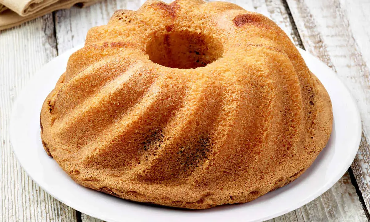 Ciambellone senza uova dorato e soffice, con la sua forma a ciambella, pronto per essere gustato.