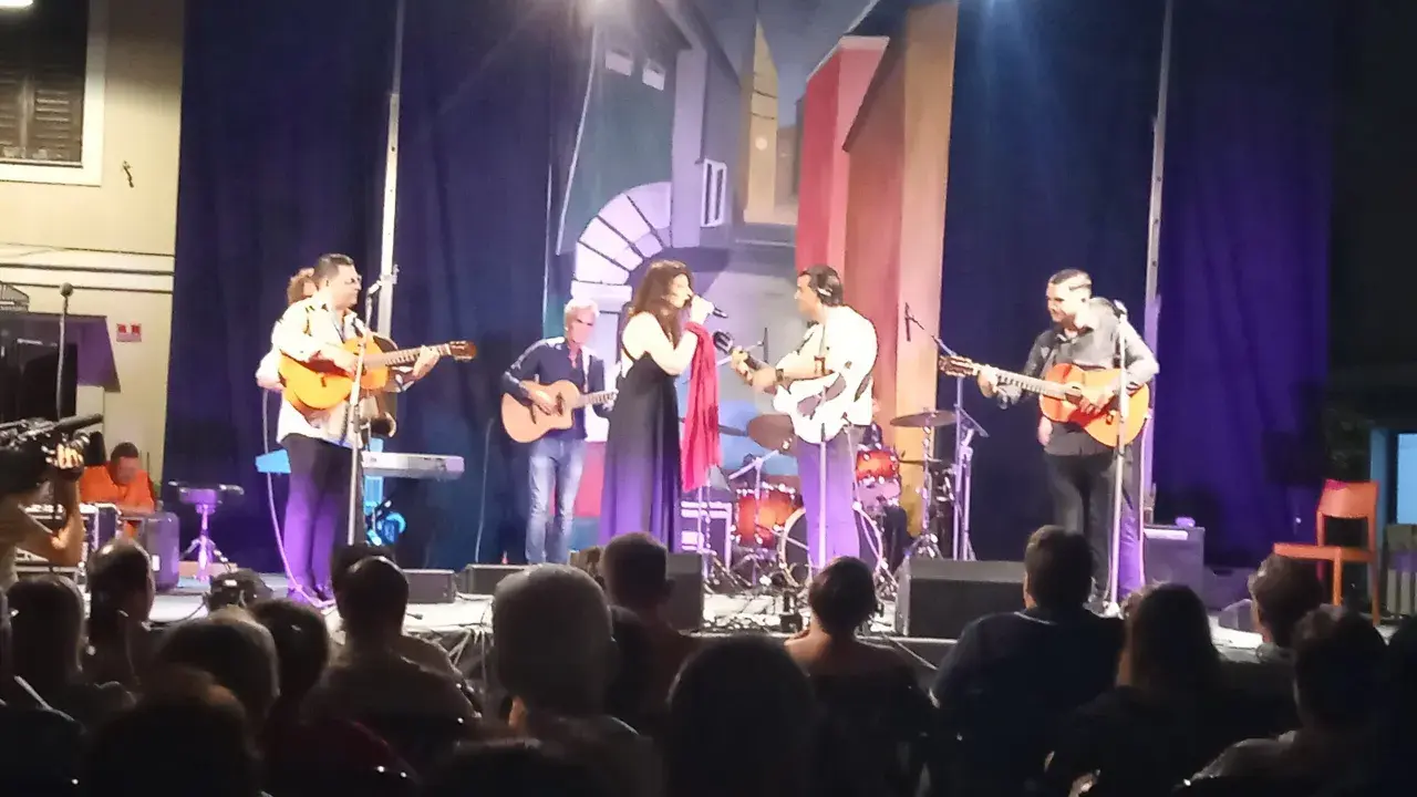 Concerto dal vivo con chitarre acustiche e voce, gli accordi di Bamboléo risuonano nell'aria.