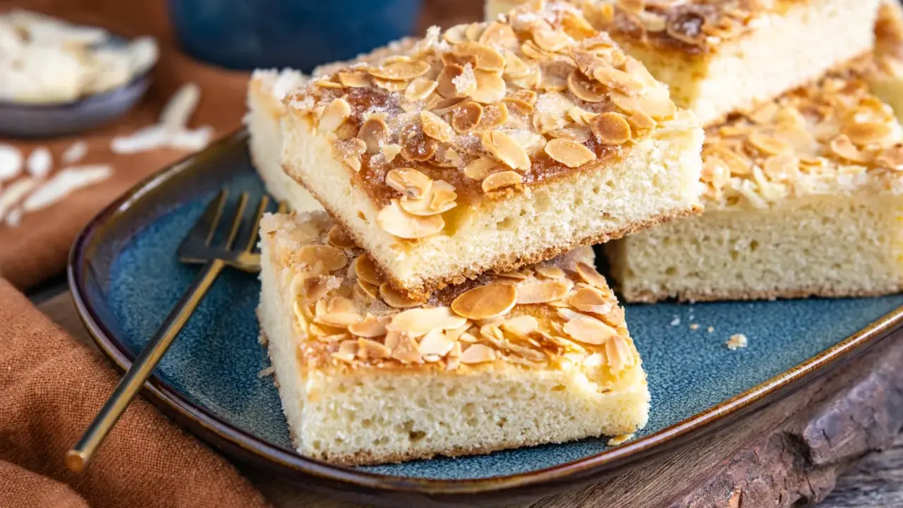 Saftige Stücke Butterkuchen mit Mandelblättchen und Zucker bestreut, bereit zum Genießen. Ein köstliches Rezept für jeden Anlass.