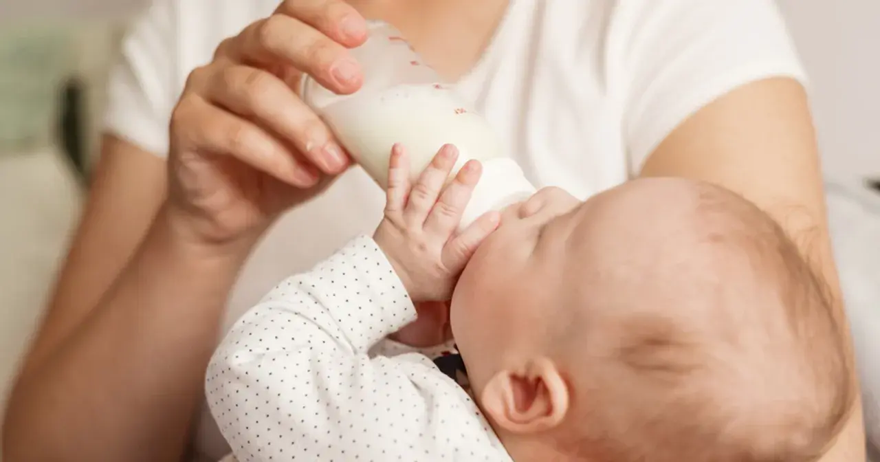 Dziecko pije mleko modyfikowane z butelki. Karmienie to może mieć różne konsekwencje dla rozwoju malucha.