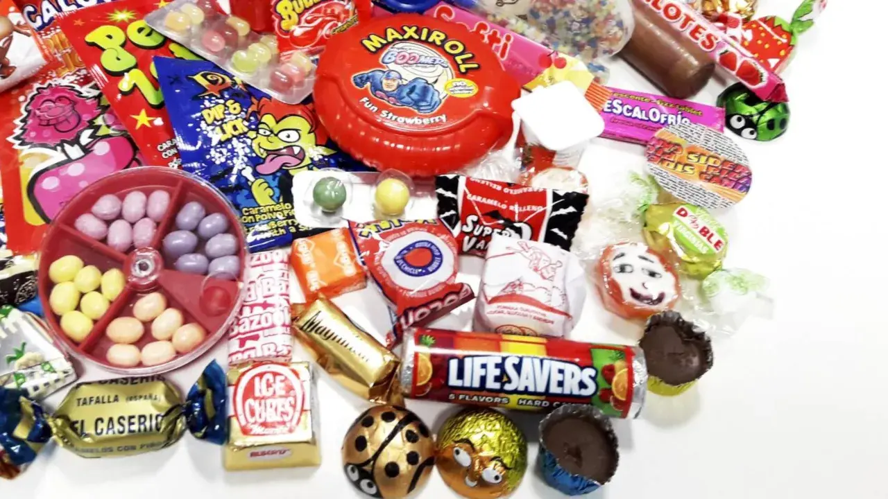 Un surtido de chuches años 60, con caramelos, chicles y chocolates, evocando la nostalgia de la infancia.