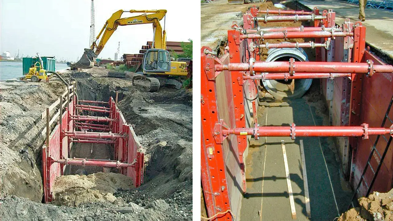 Excavación con entibación ligera para instalar tuberías. Maquinaria pesada y sistema de soporte rojo aseguran el área.