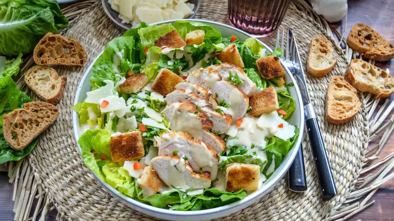 Saftiges Hähnchenbrustfilet auf knackigem Römersalat mit Croutons und cremiger Sauce – eine köstliche Caesar Salad.