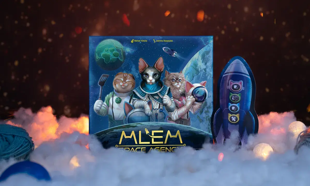 Mlem Space Agency: koty w kosmosie! Trzy futrzaki w skafandrach, jeden z łopatką, gotowe na międzygalaktyczną przygodę. Obok rakieta z kocimi symbolami.
