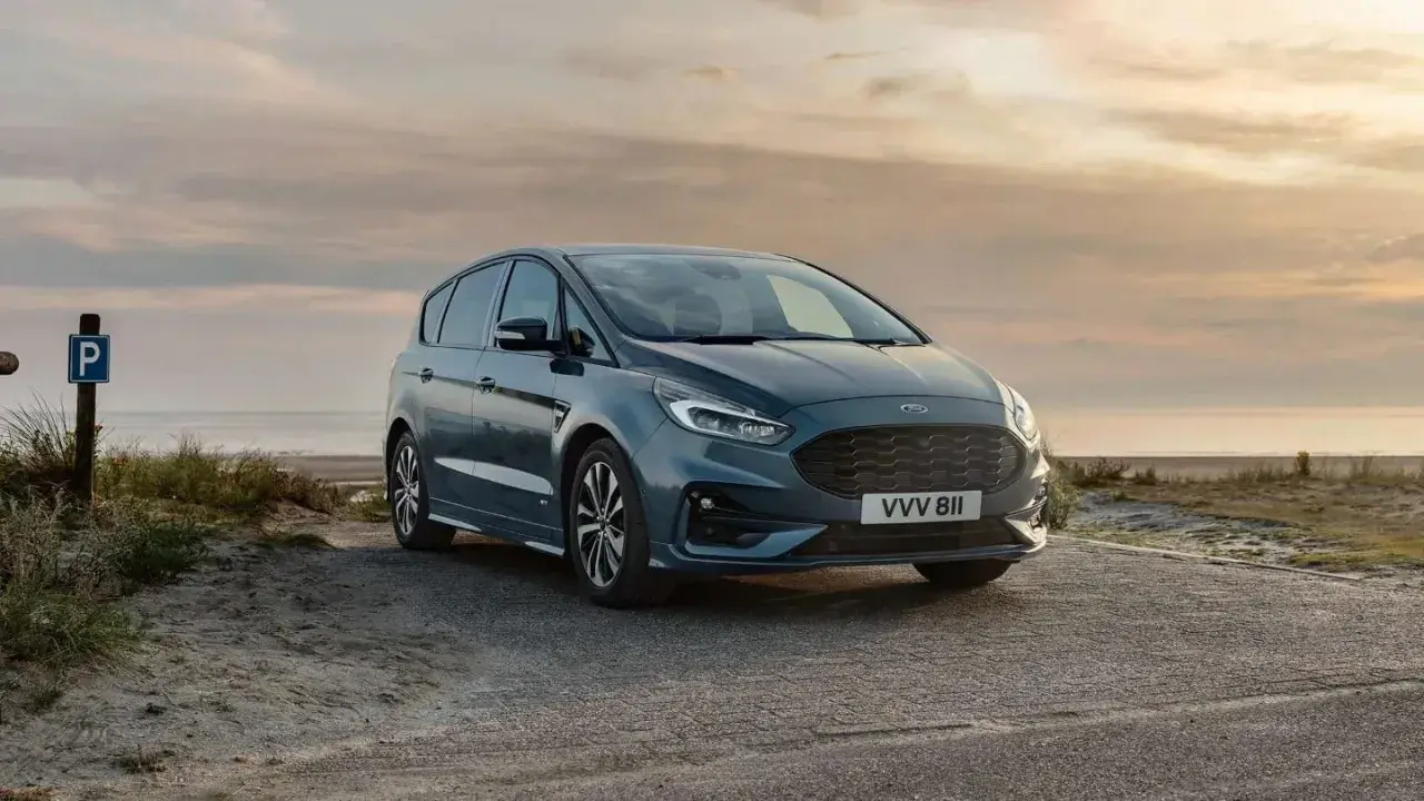 Ford S-Max gris aparcado en la playa al atardecer. Las medidas del Ford S-Max son ideales para escapadas familiares.