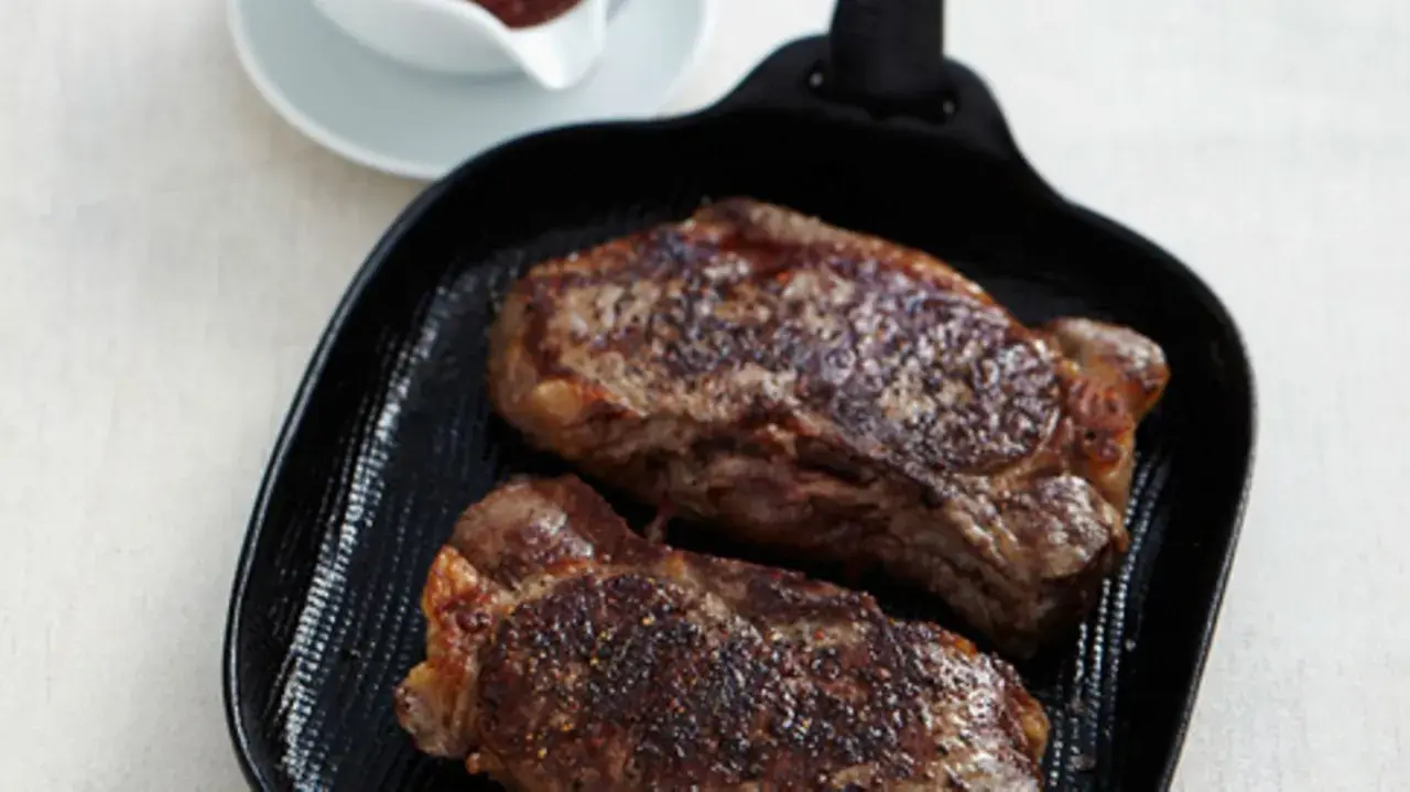 Zwei saftige Rumpsteaks braten in einer Grillpfanne, perfekt gewürzt und bereit zum Genuss.