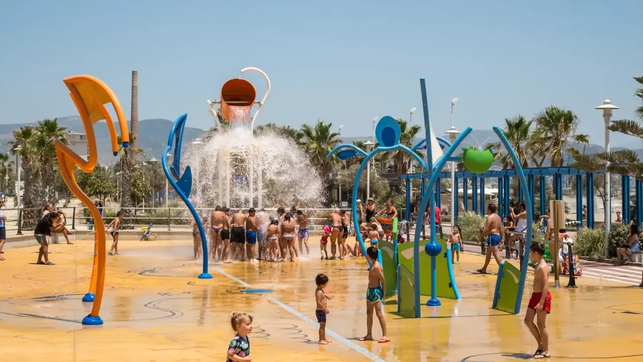 Wasserspaß für die ganze Familie in Malaga mit Kindern. Ein bunter Wasserspielplatz mit Rutschen und Spritzdüsen.