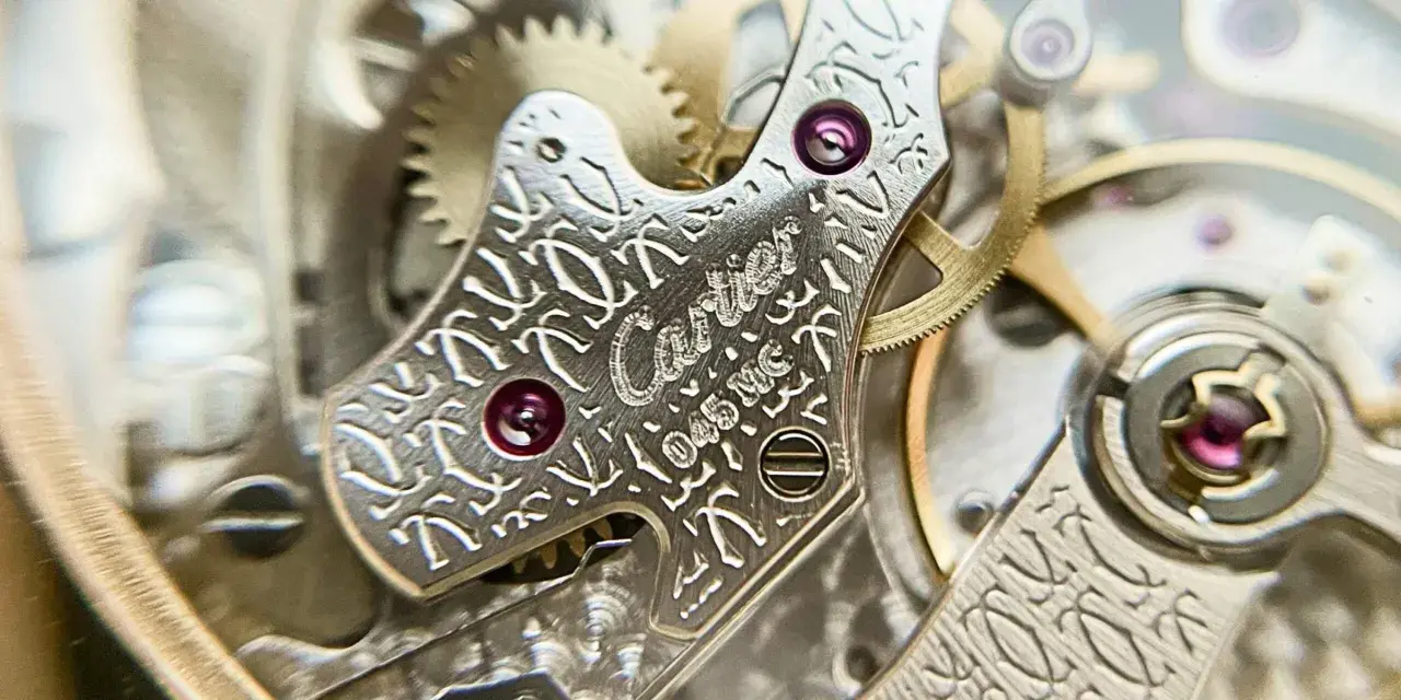 Dettaglio del movimento di un orologio Cartier, con incisioni guilloché e rubini. La joux perret, un capolavoro di precisione.
