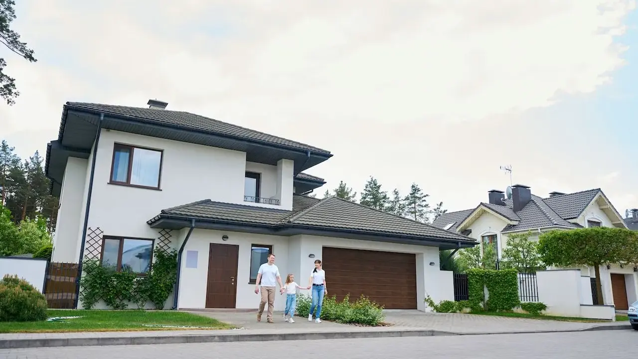 Rodzina spaceruje przed nowoczesnymi projektami domów piętrowych.