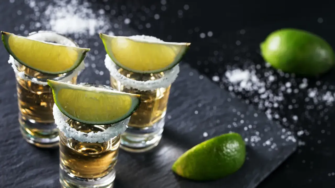 Kieliszki tequili z solą i limonką. Idealne dodatki, by wiedzieć, z czym pić tequilę.