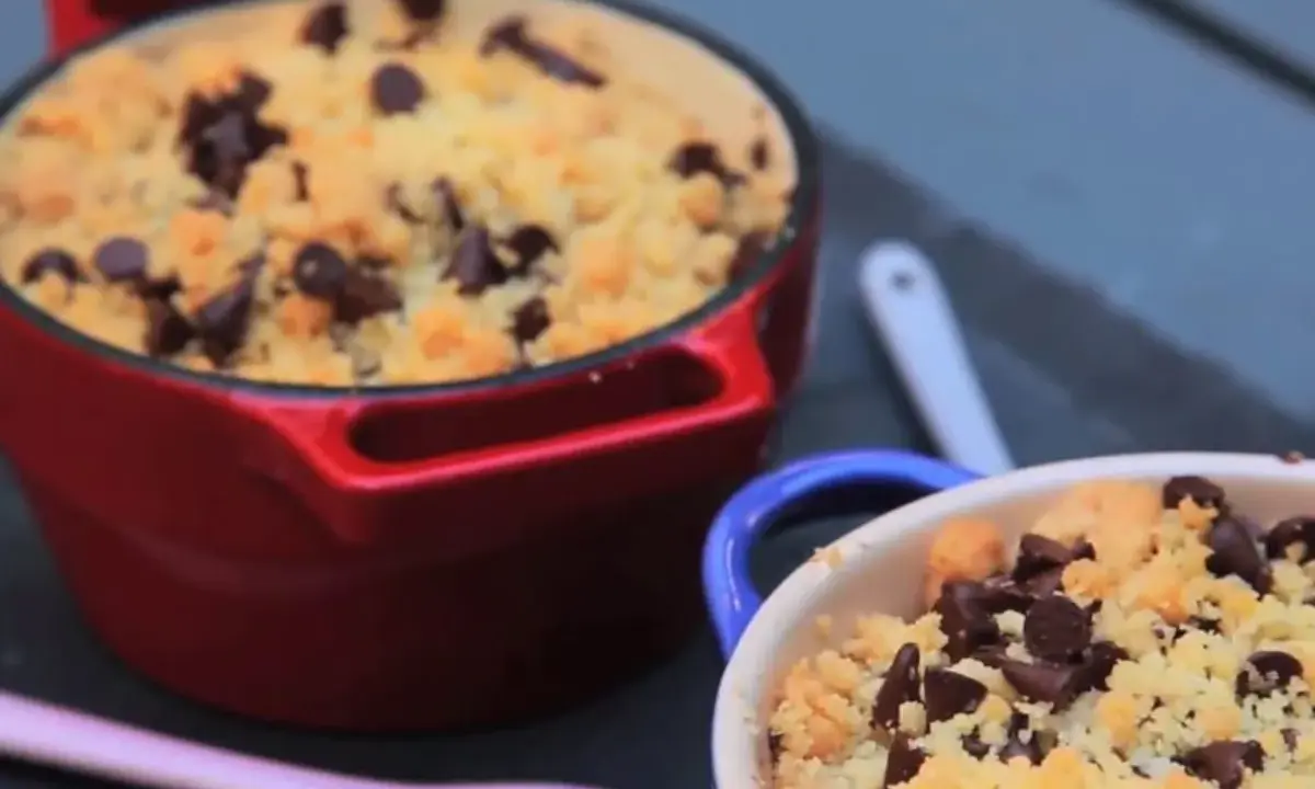 Deux ramequins de crumble pomme banane chocolat, l'un rouge, l'autre bleu, garnis de pépites de chocolat.