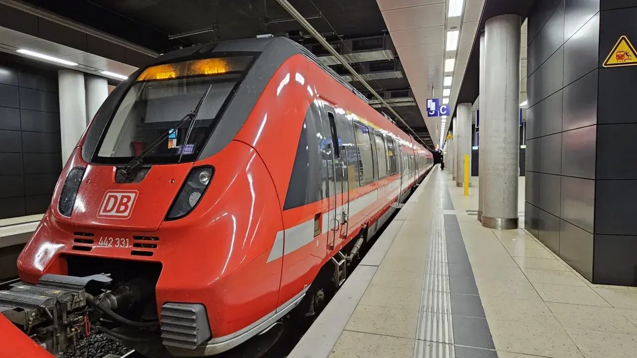 Röd DB-tåg på en station, redo att ta dig från berlin flygplats till centrum.