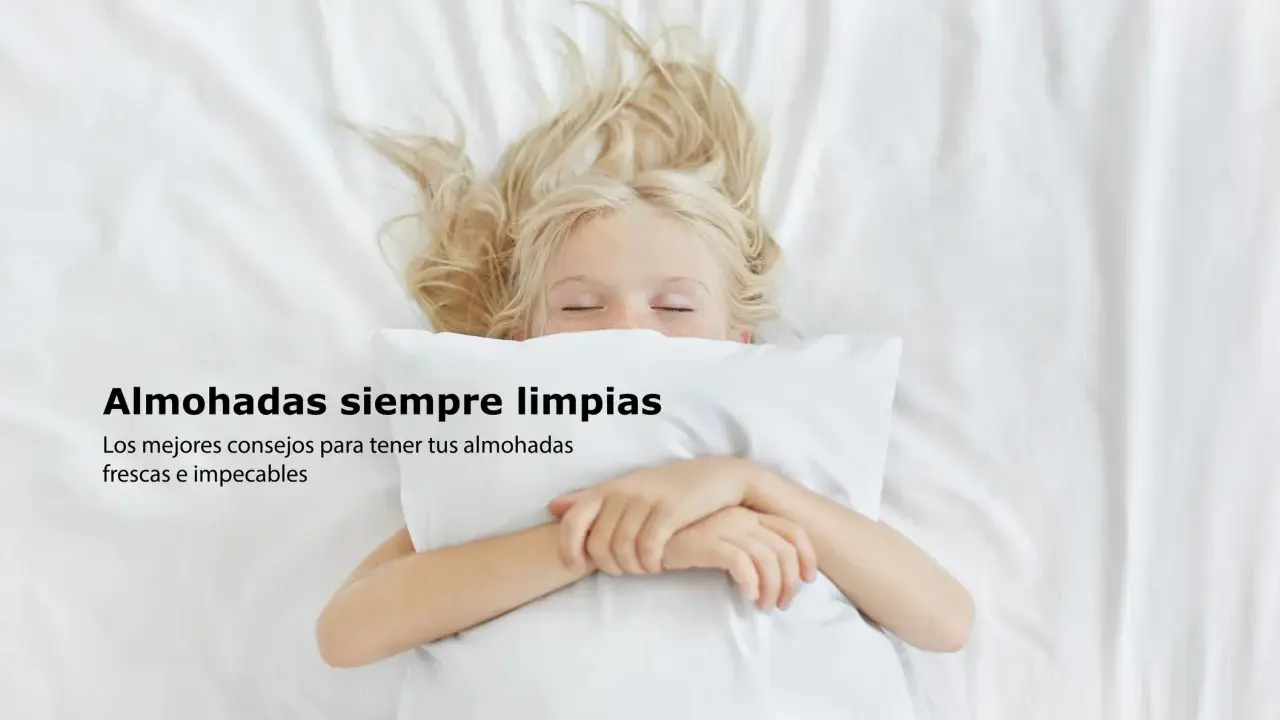 Niña rubia duerme abrazada a una almohada blanca. Consejos sobre como lavar almohadas para que estén frescas e impecables.