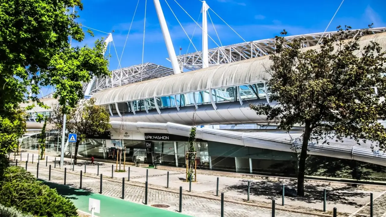 Moderne Architektur auf dem Expo Gelände Lissabon mit einem langen, geschwungenen Dach und Glasfassaden.