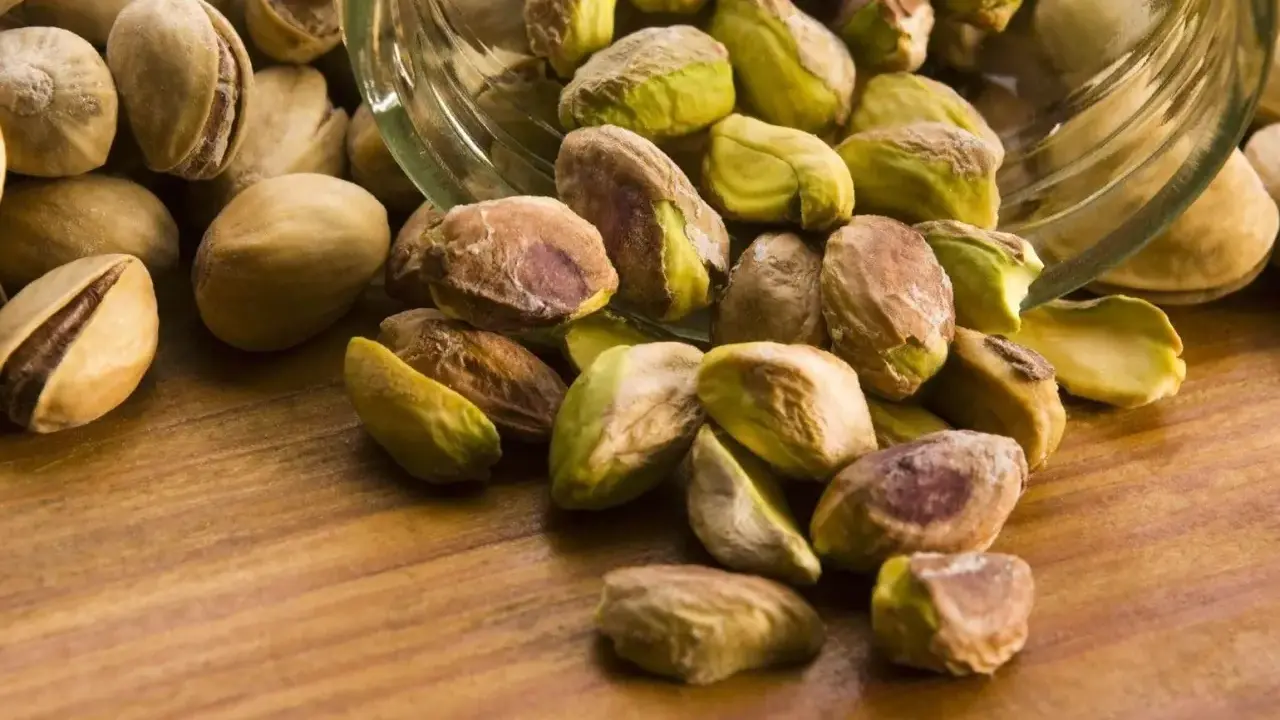 Garść pistacji wysypana ze słoika. Czy pistacje są kaloryczne? Tak, ale zdrowe!
