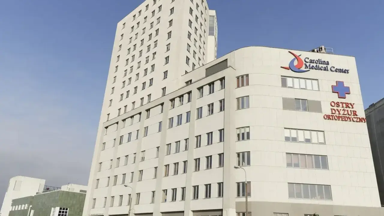 Nowoczesny budynek Carolina Medical Center w Warszawie z napisem "Ostry Dyżur Ortopedyczny".