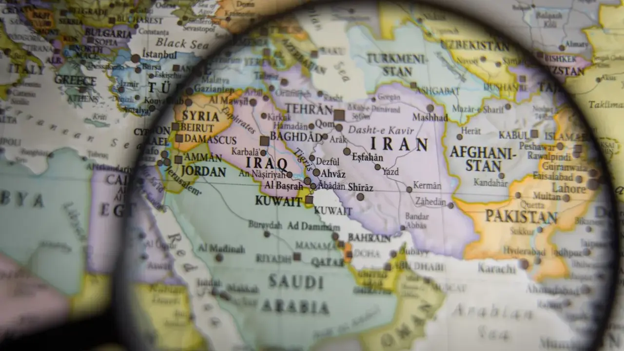 Mapa świata pod lupą, widoczne kraje Bliskiego Wschodu i Azji Południowej. W centrum Iran, Irak, Arabia Saudyjska.