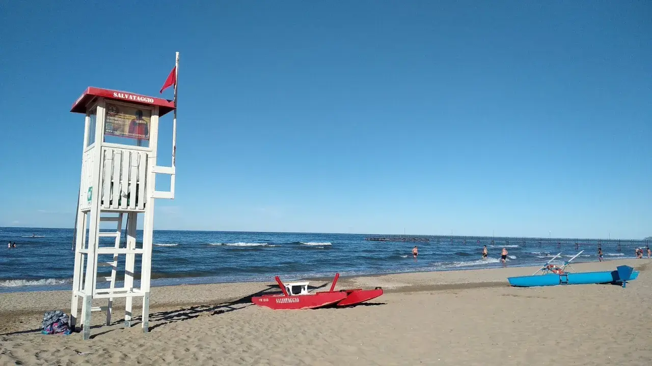 Torre di salvataggio e barchini sulla spiaggia di Rimini, pronti per nuove storie di mare.