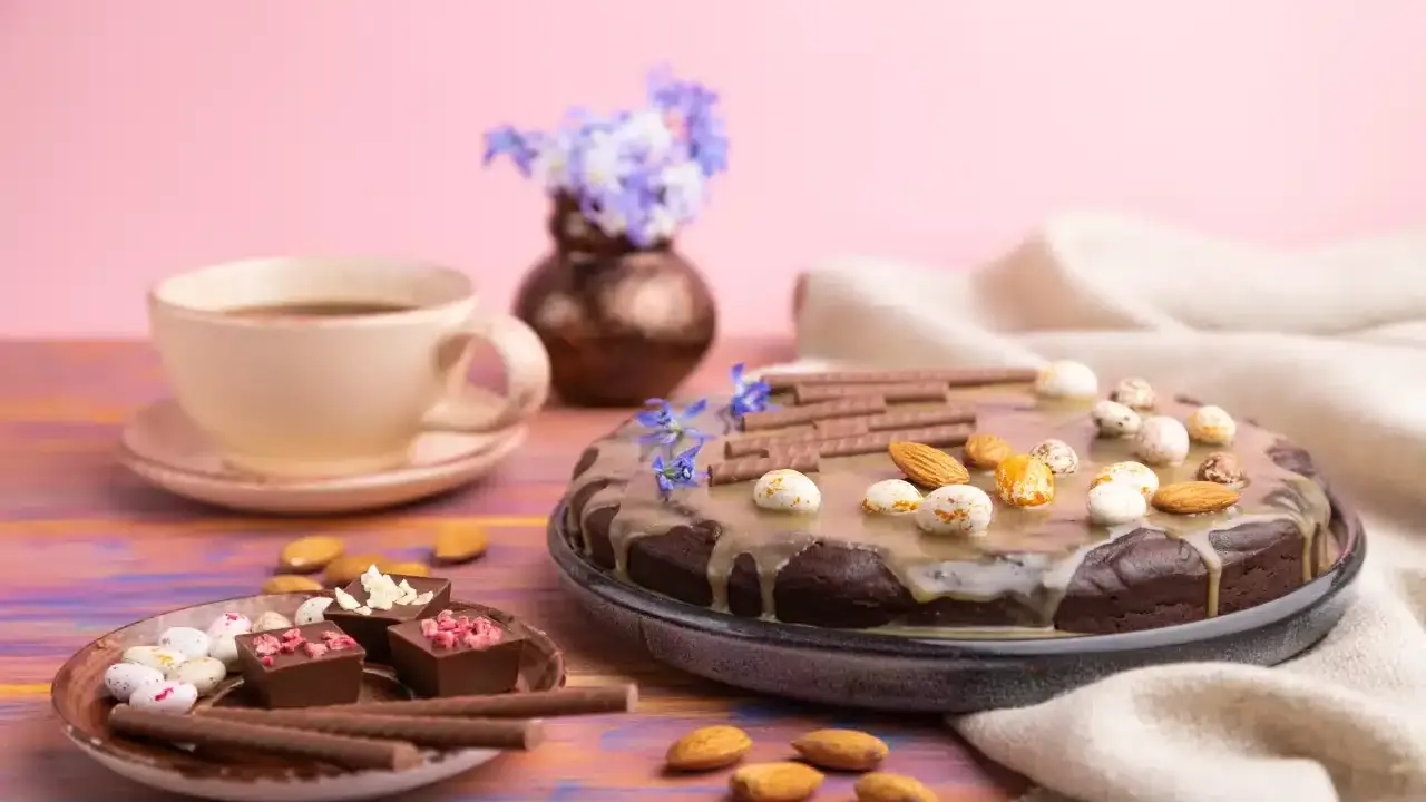 Czekoladowy tort i pralinki na talerzyku, kawa i kwiaty. Idealny przepis na zdrowe słodycze.