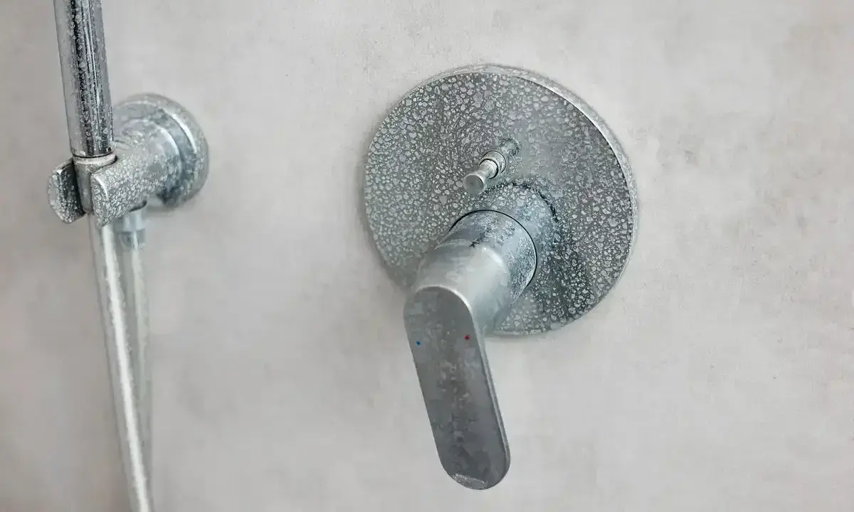 Mitigeur thermostatique de douche entartré, prêt à démonter sans vis. Le levier est en position basse.